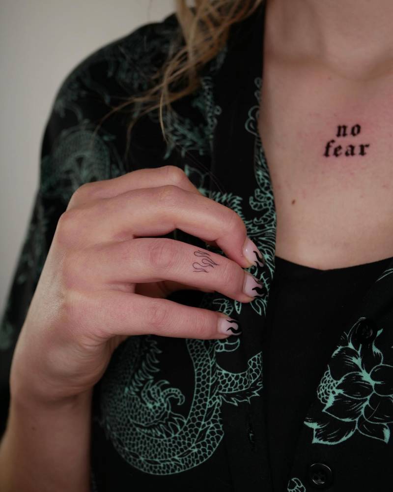 Lettering tattoo that says "no fear" located on the chest.