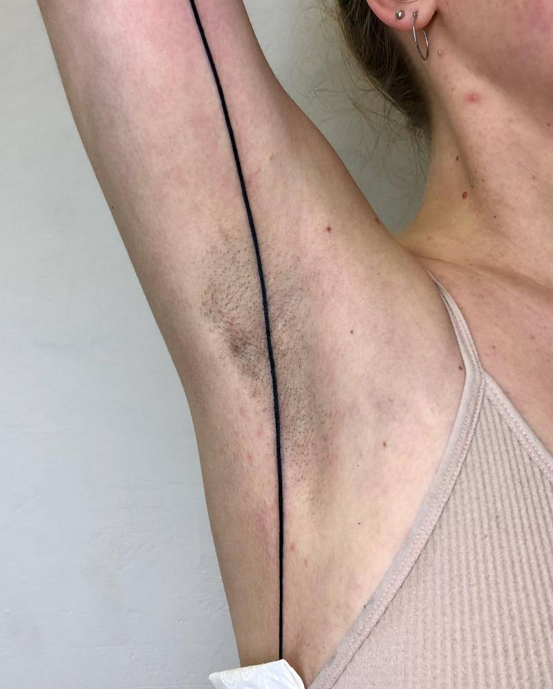 Minimalistic line tattoo located on the armpit.