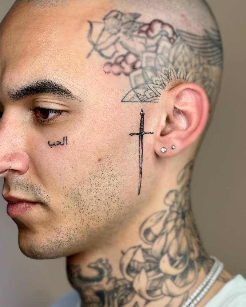 Sword tattoo located on the face.
