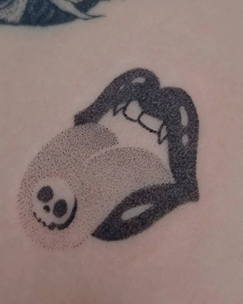 Hand poked Vampire mouth LSD trip tattoo located on the shoulder blade.