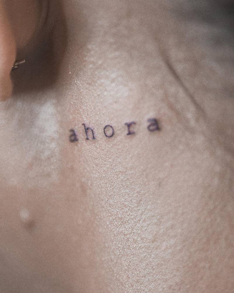 Tattoo that says "ahora" located on the neck.