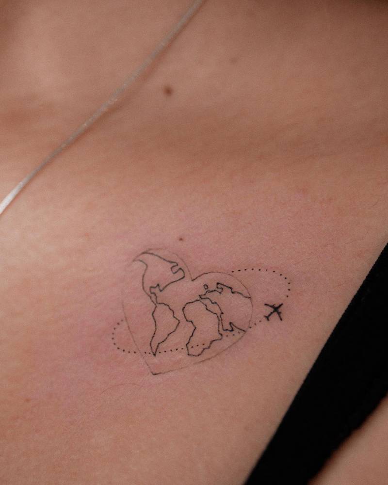 FIne line around the world tattoo located on the collarbone.