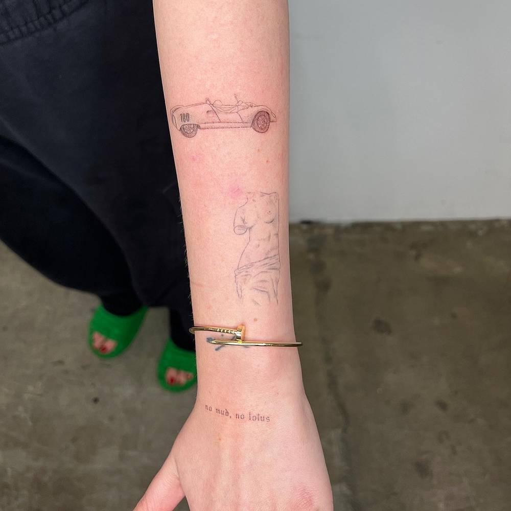 Fresh racing car and healed Venus de Milo tattoos located on the forearm.