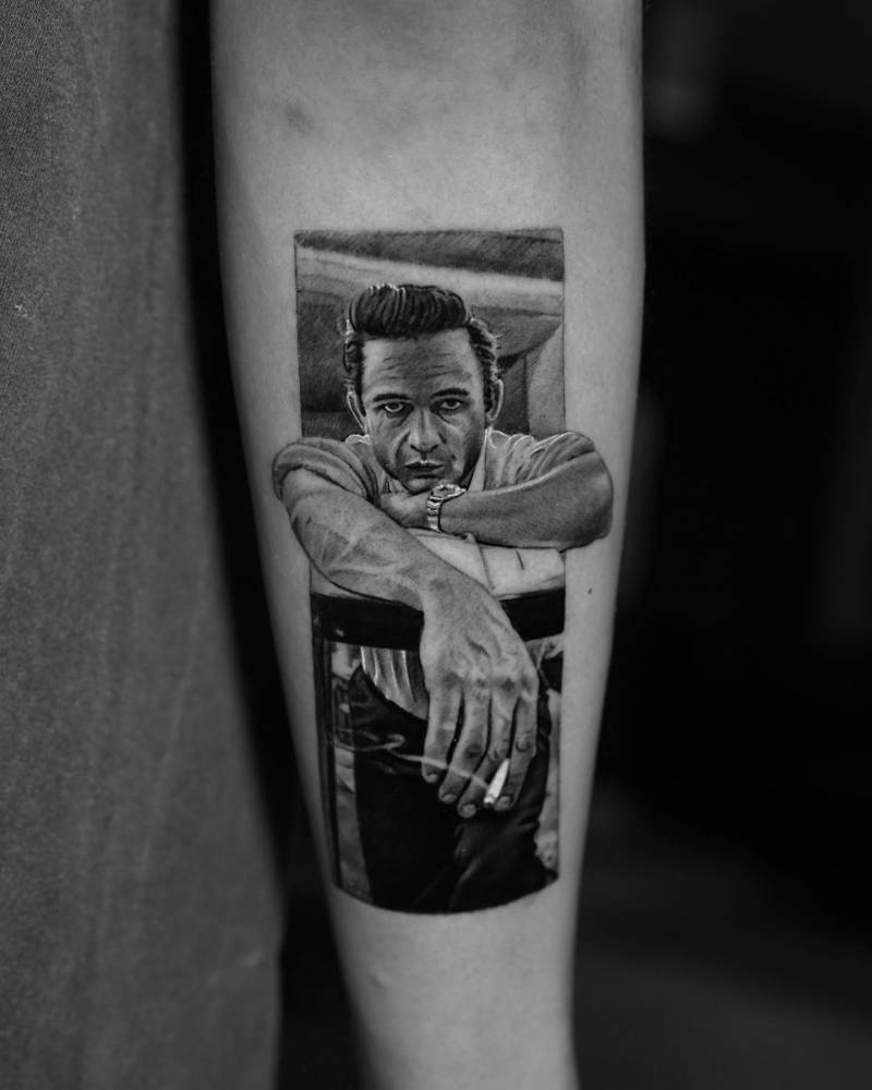 Johnny Cash portrait tattoo located on the forearm, micro-realistic style.