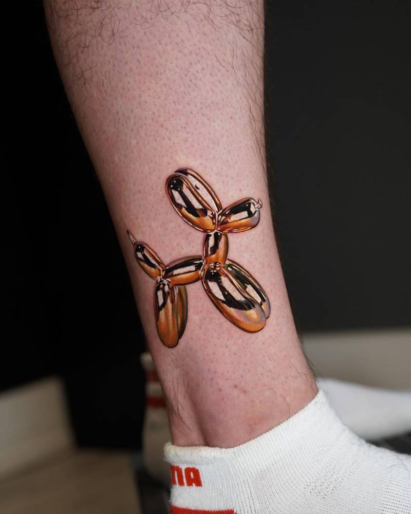 Metallic effect balloon dog tattoo located on the ankle.