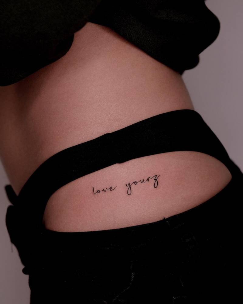 "Love yourz" lettering tattoo located on the hip.