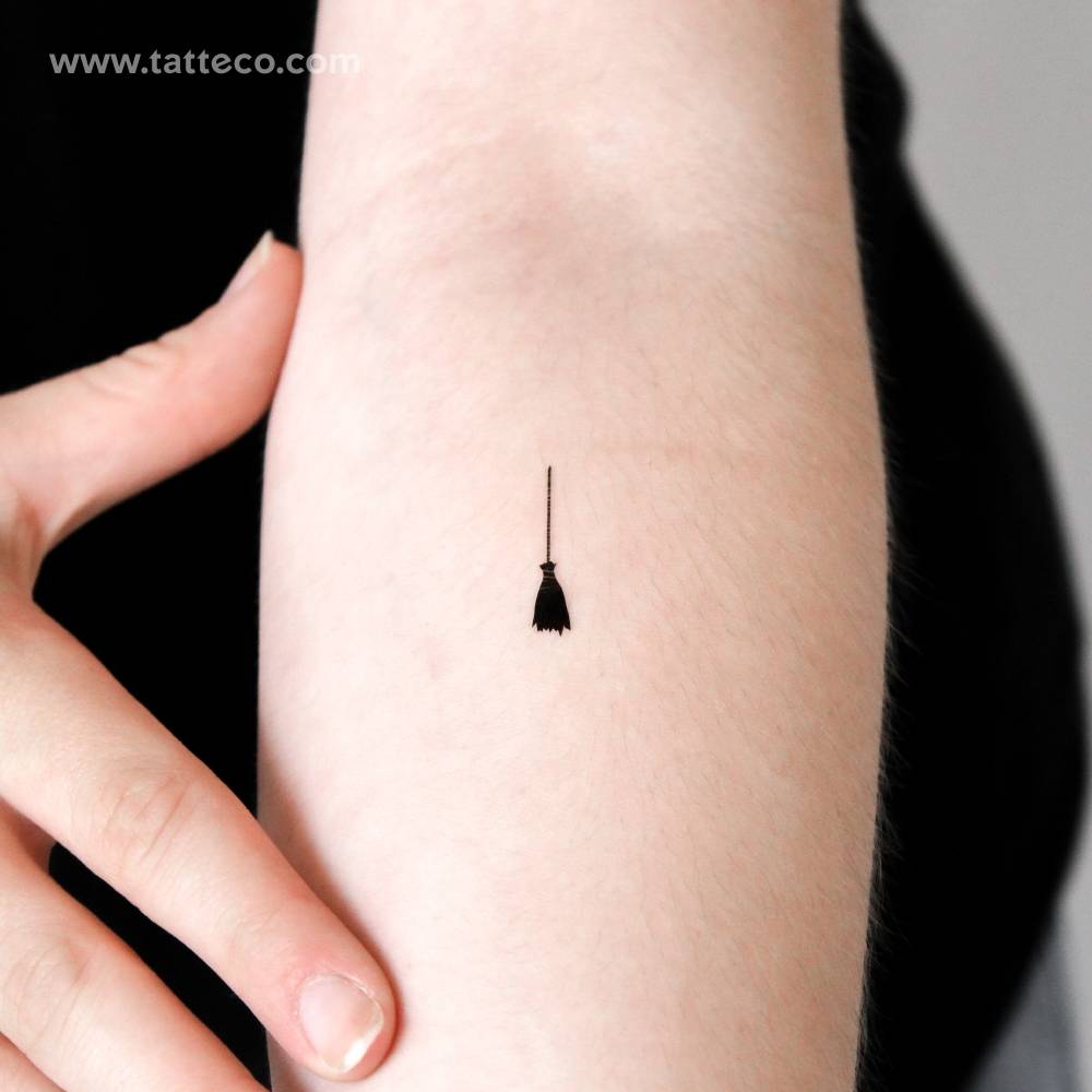 Tiny broomstick temporary tattoo located on the inner forearm.