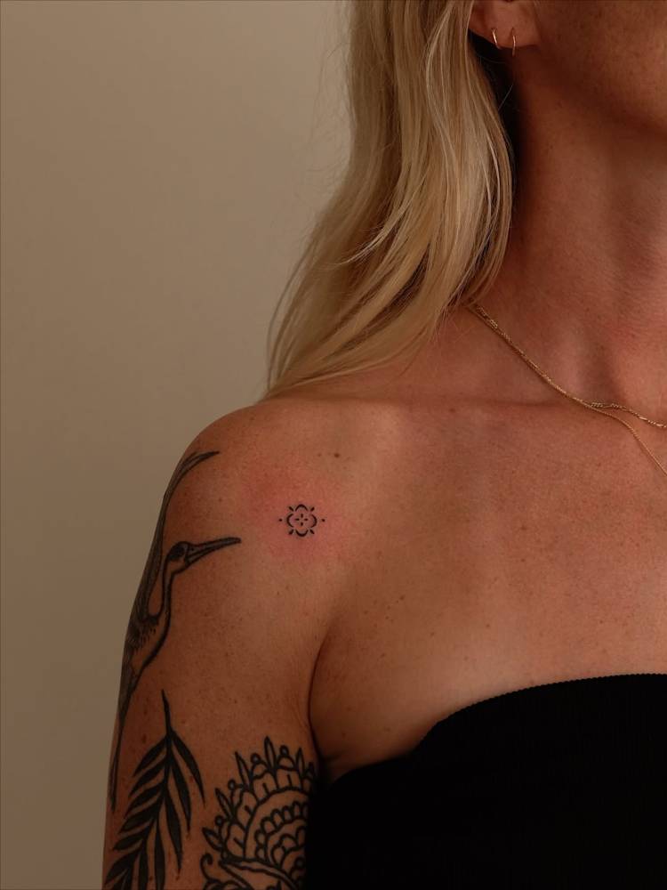 Tiny minimalistic ornament tattooed on the shoulder.