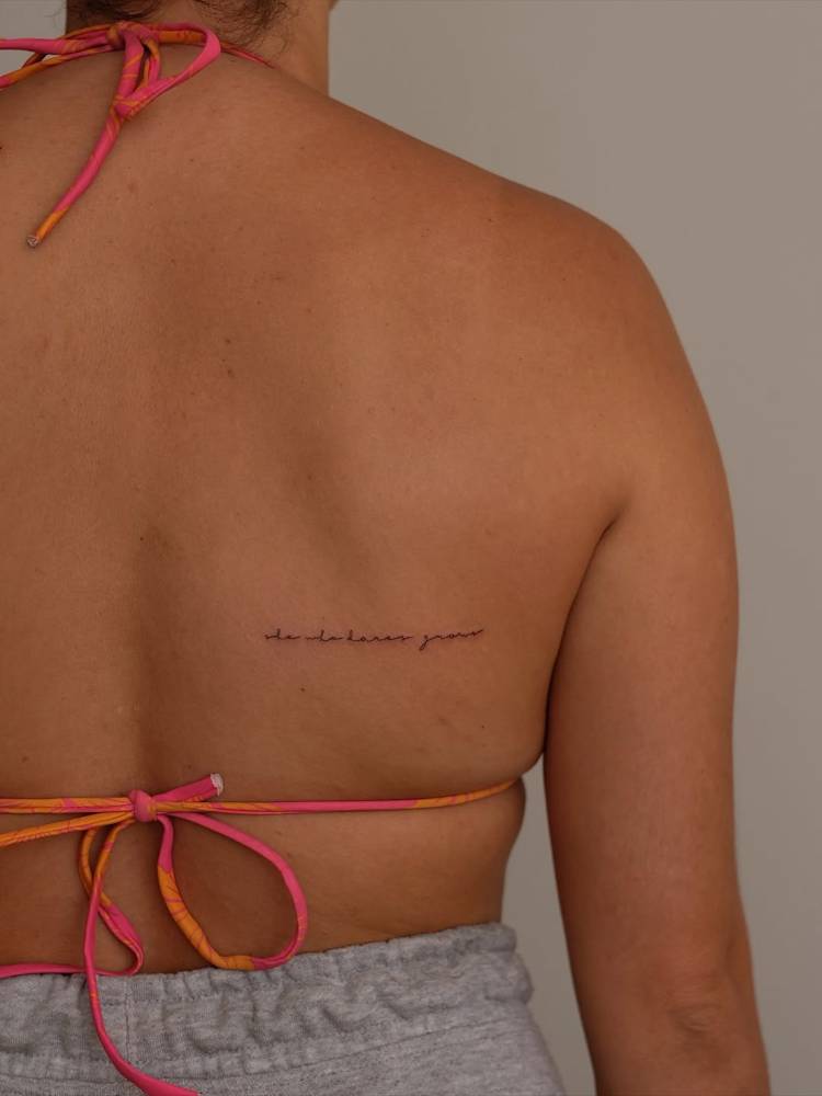 "She who dares grows" lettering tattoo in handwritten font.