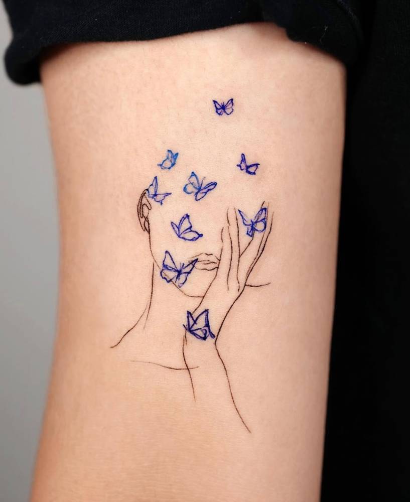 Butterfly woman tattoo in sketch work style located on the bicep.