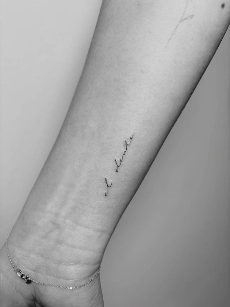 "Al dente" lettering tattoo in handwritten font located on the wrist.