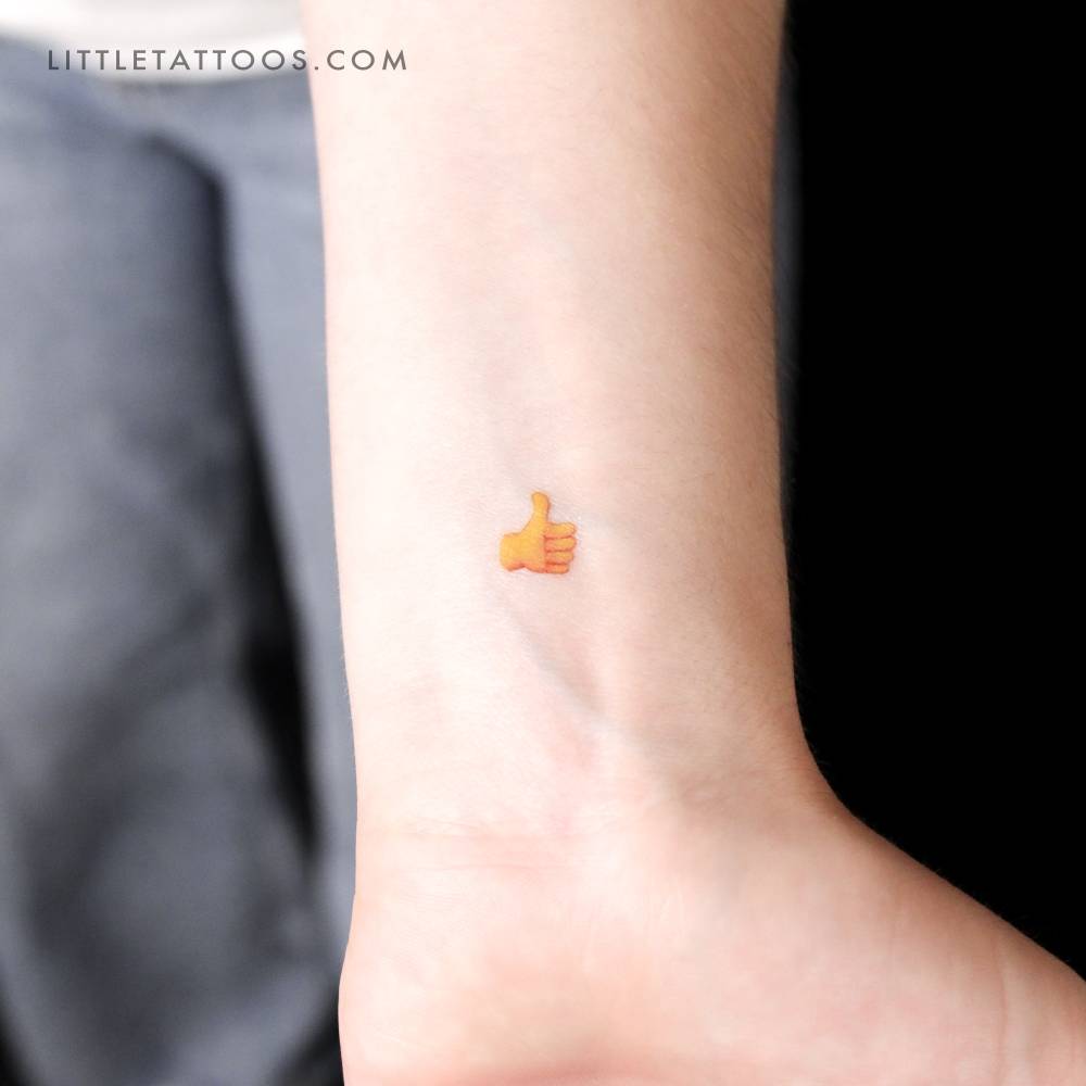 Thumb up emoji temporary tattoo located on the wrist.