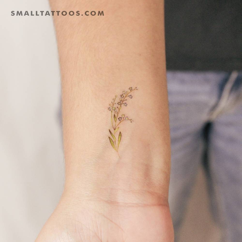 Small watercolor style forget-me-not temporary tattoo placed on the wrist.