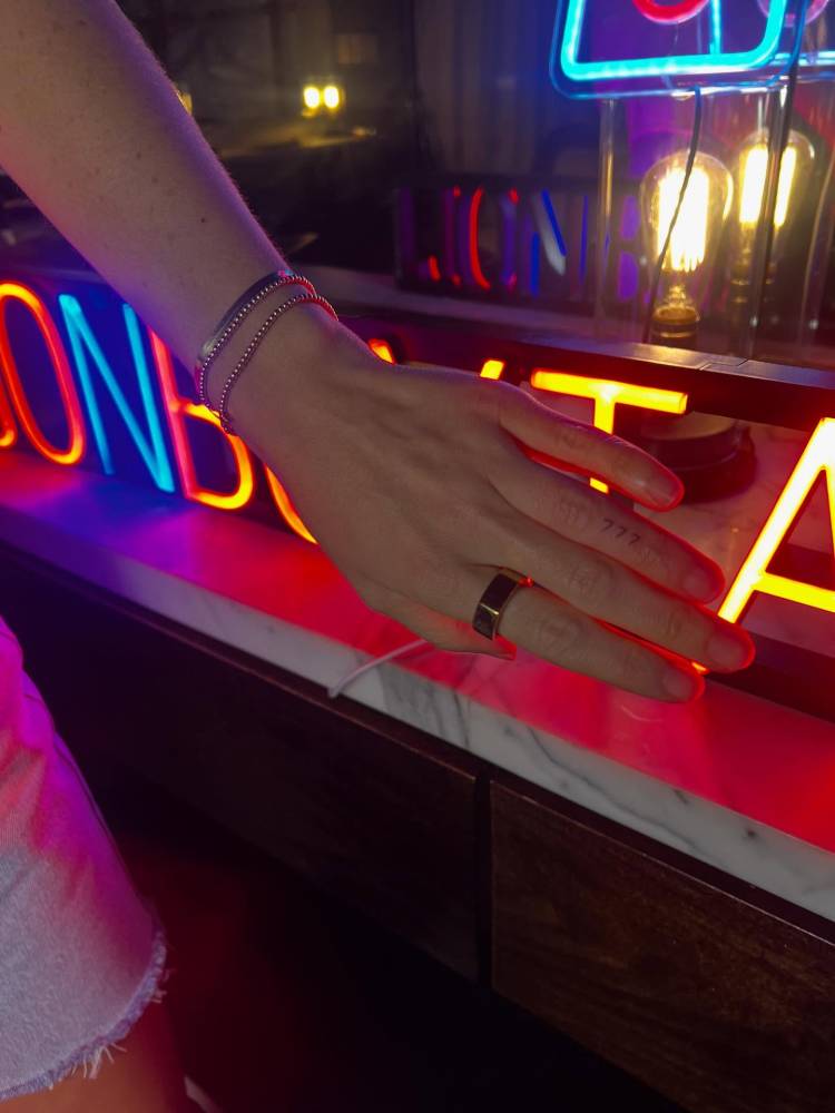 Angel number "777" tattoo located on the finger.