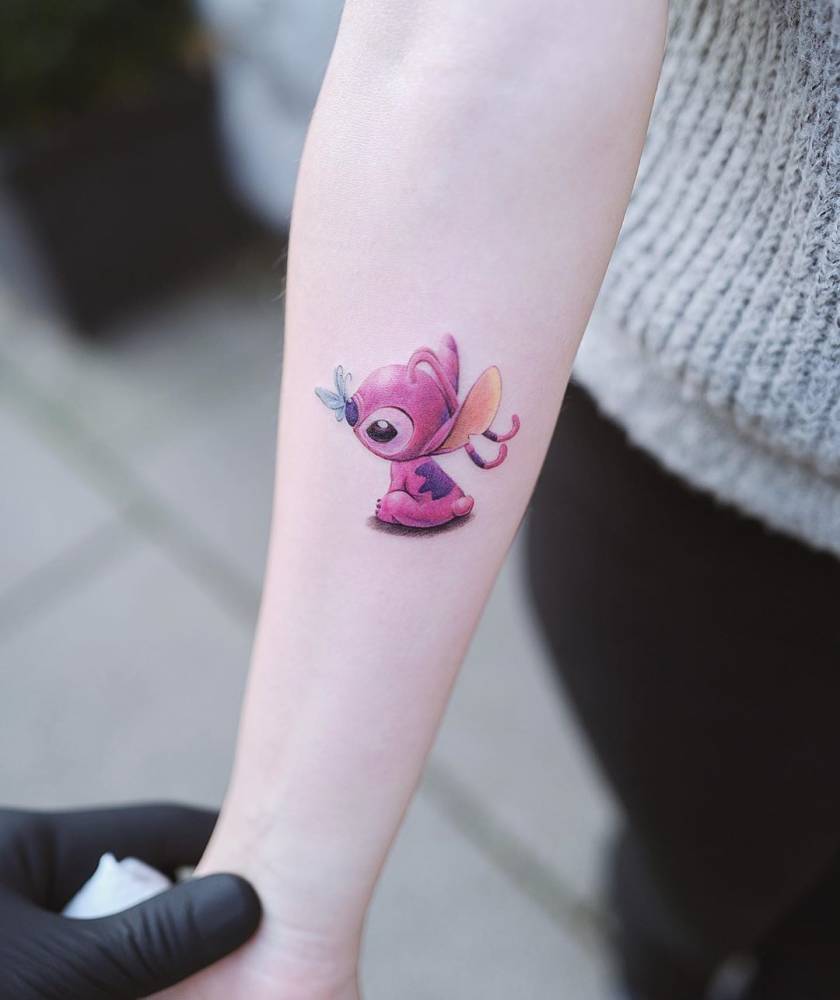 Stitch tattoo in cartoon style located on the inner forearm.