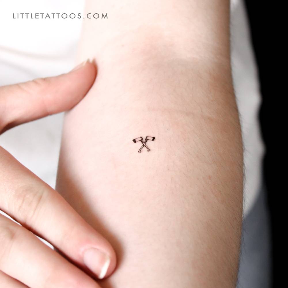 Hatchet couple temporary tattoo located on the inner forearm.