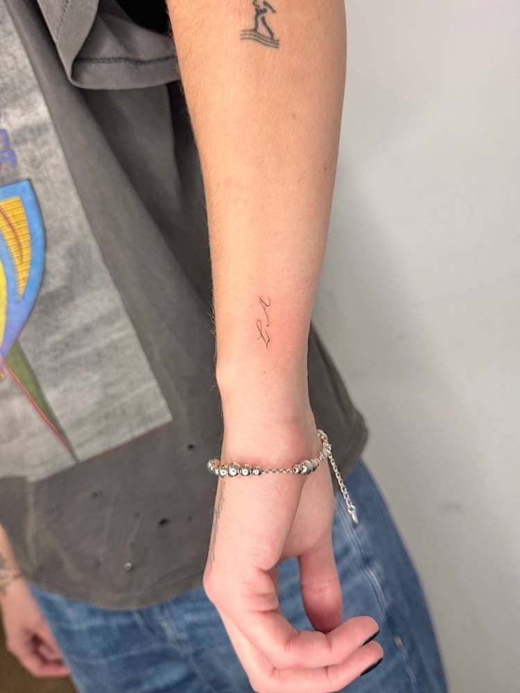 "LA" lettering tattoo located on the wrist.