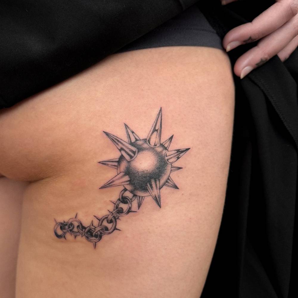 Flail tattoo in illustrative style located on the hip.