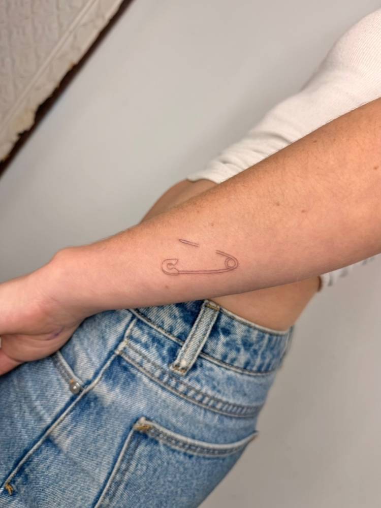 Single needle safety pin tattoo done on the wrist.