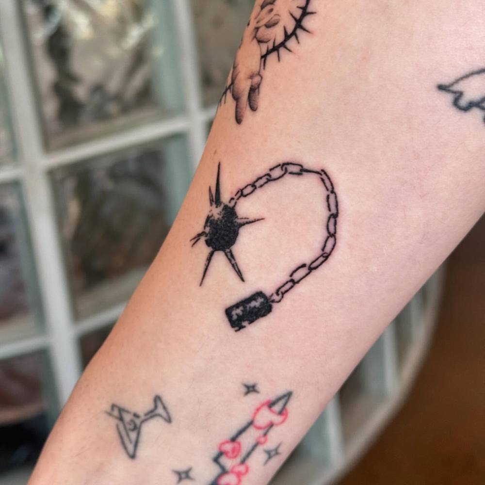 Blackwork style flail tattoo located on the inner forearm.