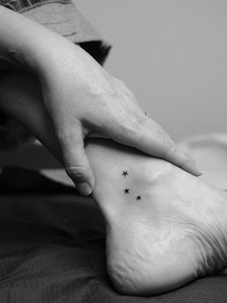 Minimalistic stars tattoo located on the ankle.