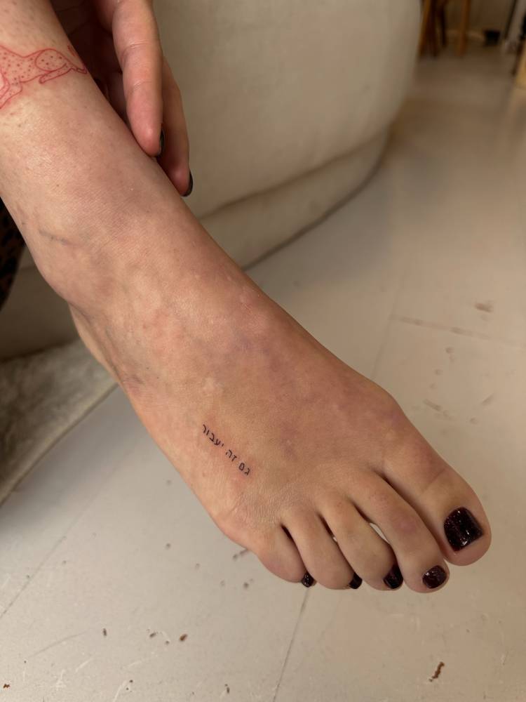 Hebrew lettering tattoo placed on the foot.