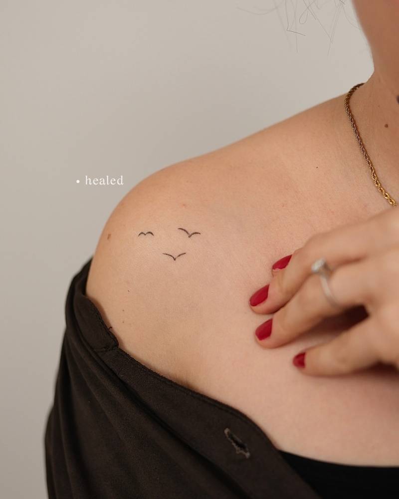 Healed minimalistic flying birds tattoo located on the shoulder.