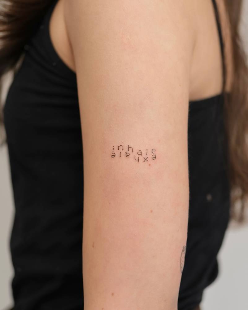 "Inhale exhale" tattoo located on the upper arm.
