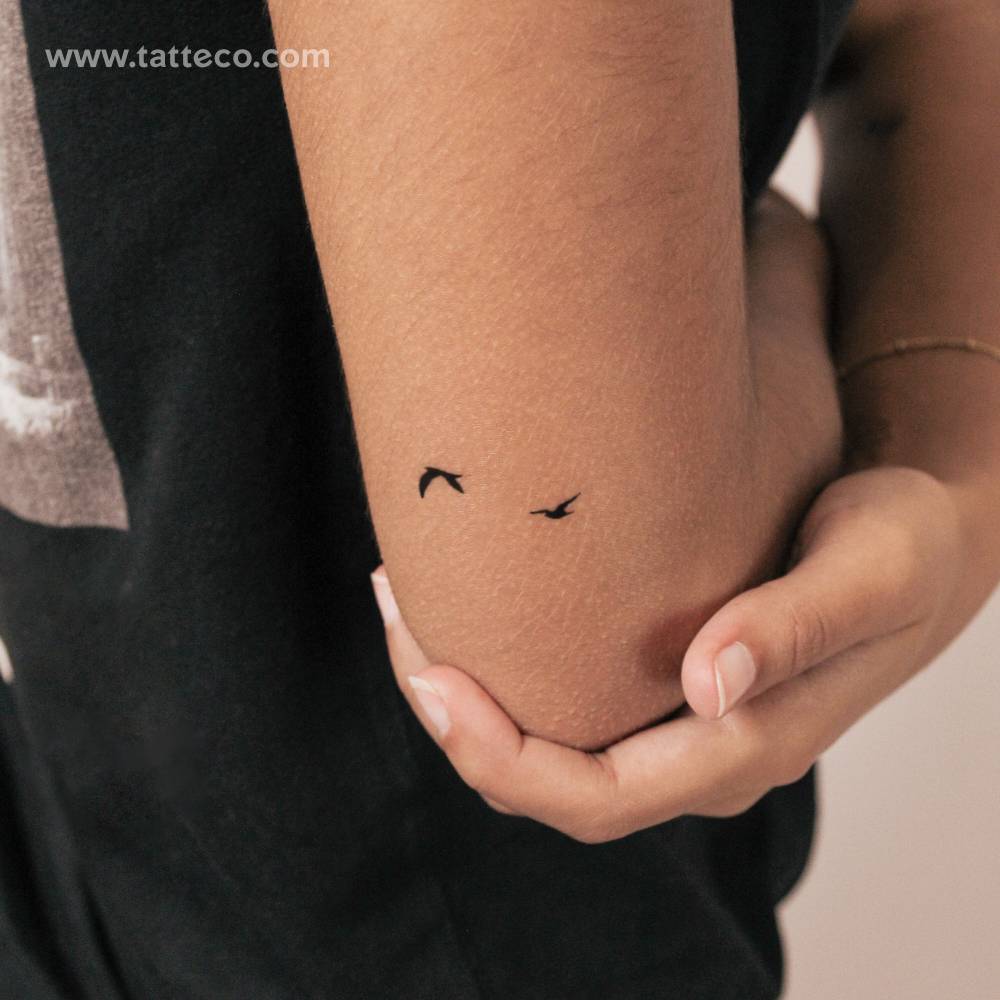 Two minimalistic flying birds semi-permanent tattoo.