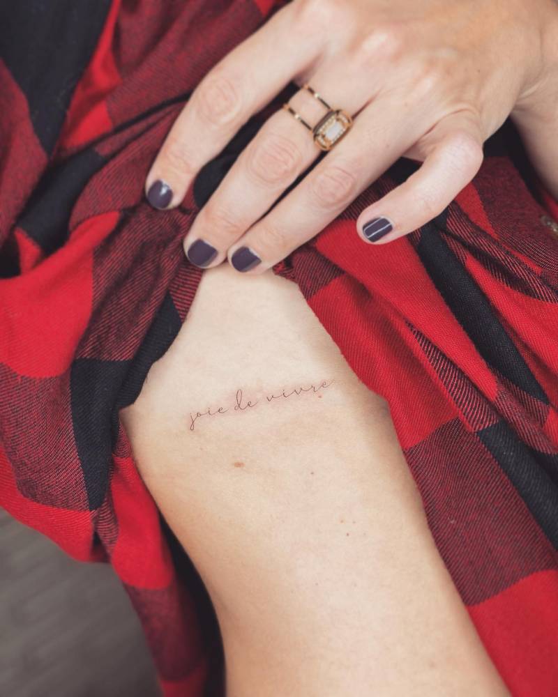 "Joie de vivre" lettering tattoo placed on the rib.