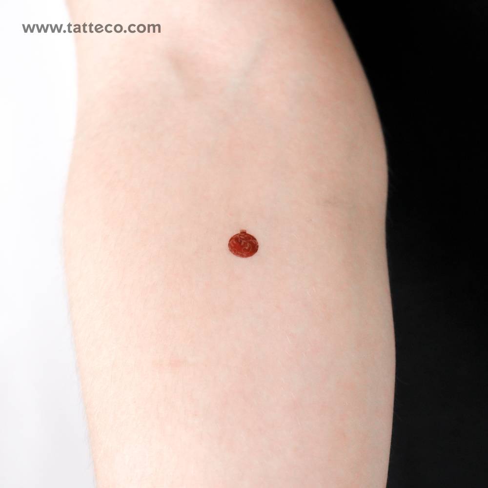 Christmas ball temporary tattoo located on the inner forearm.