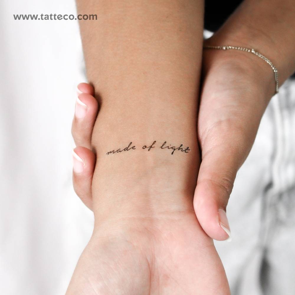 "Made of light" in handwritten font temporary tattoo located on the wrist.