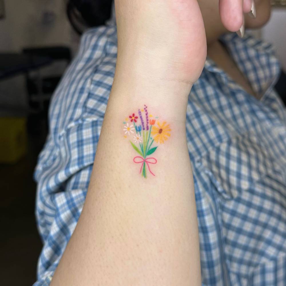 Hand poked flower bouquet tattoo in watercolor style.