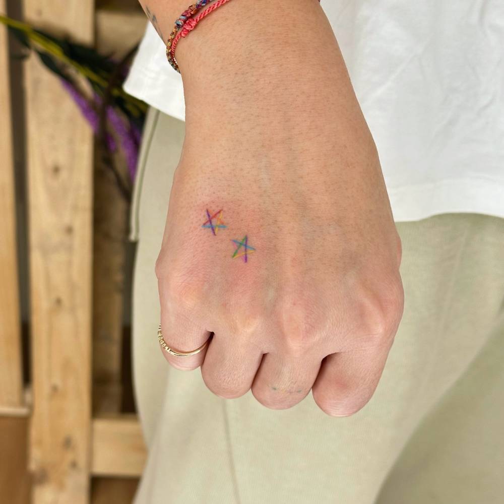 Star couple tattoo in minimalistic style placed on the hand.