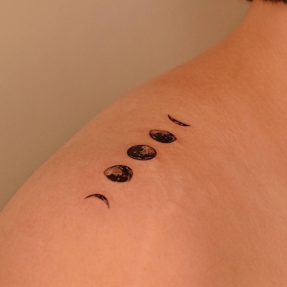 Micro-realistic style moon phases tattoo done on the top of shoulder.