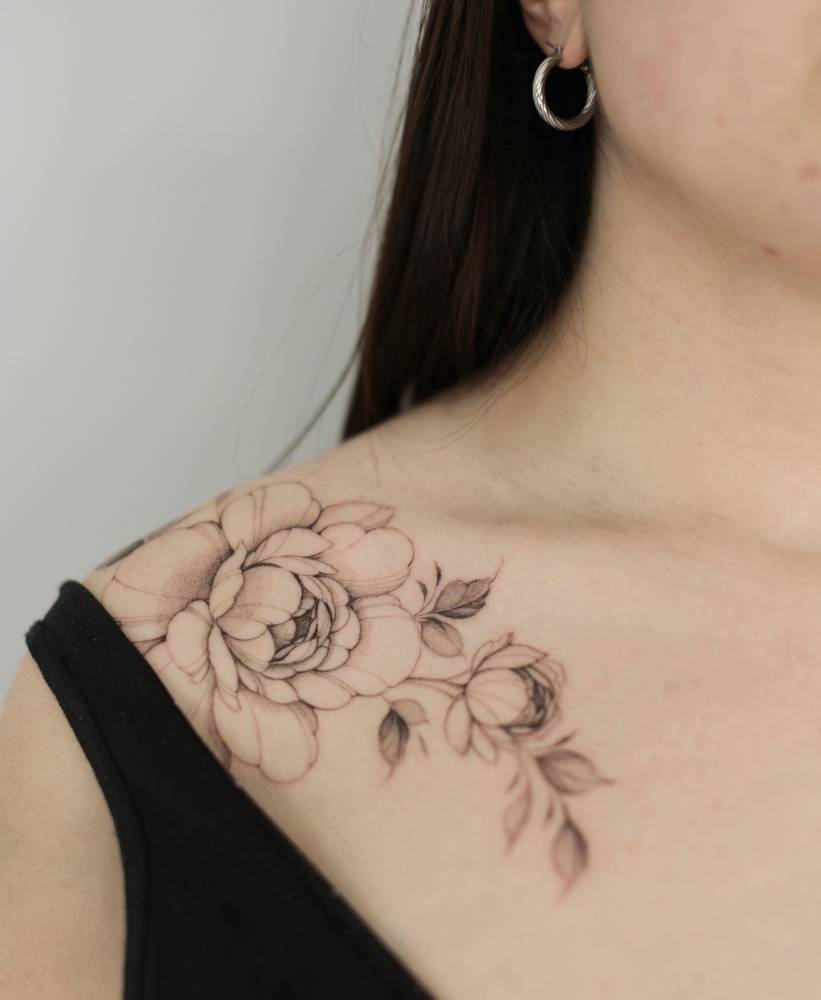 Illustrative style peony tattoo located on the collarbone.