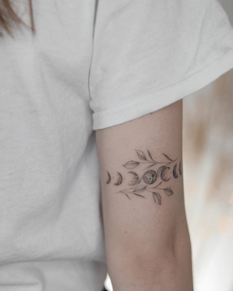 Moon phases and leaves tattoo located on the tricep.