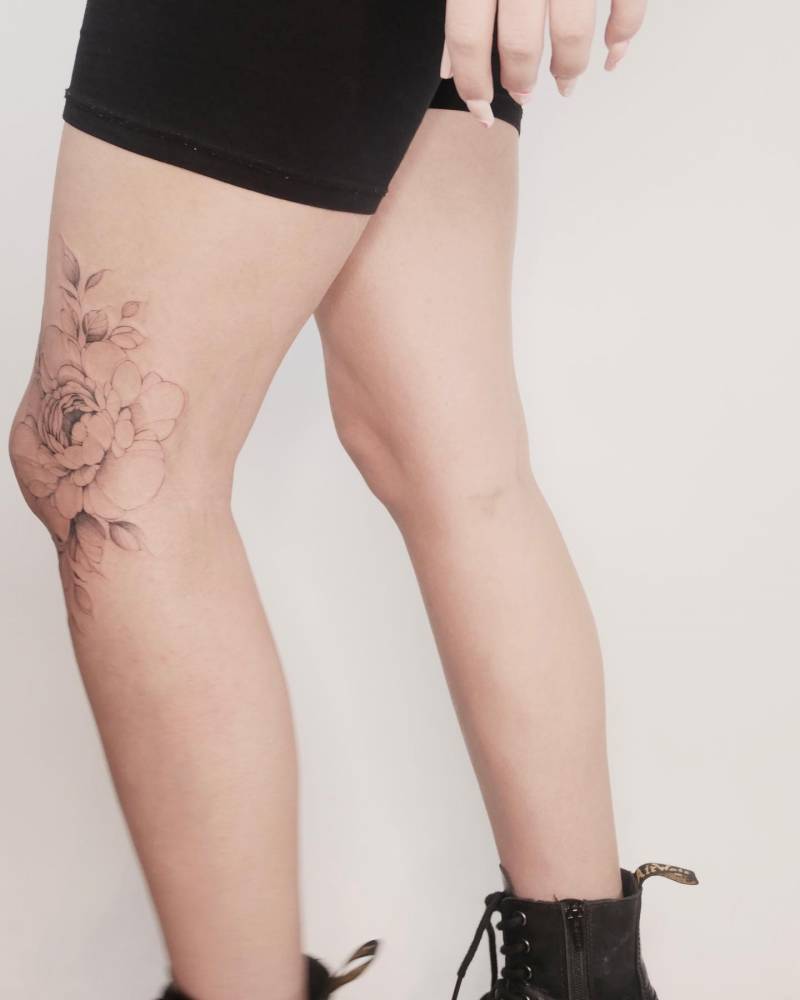 Peony tattoo located on the knee, illustrative style.
