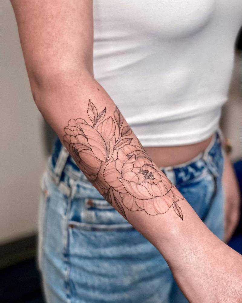 Illustrative style peony tattoo located on the forearm.