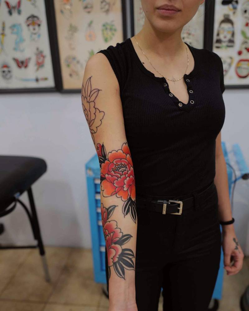 Traditional style peony tattoo located on the arm.