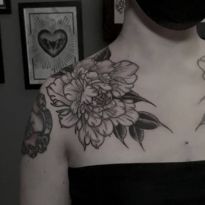 Blackwork peony tattoo on the collarbone.