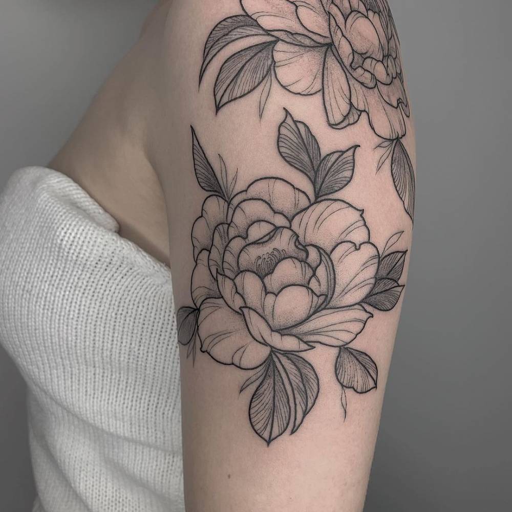 Peonies tattoo on the upper arm.