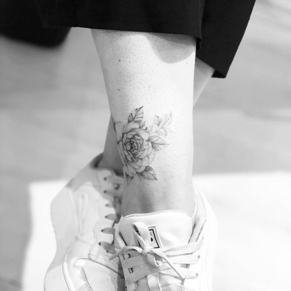 Fine line peonies tattooed on the ankle.