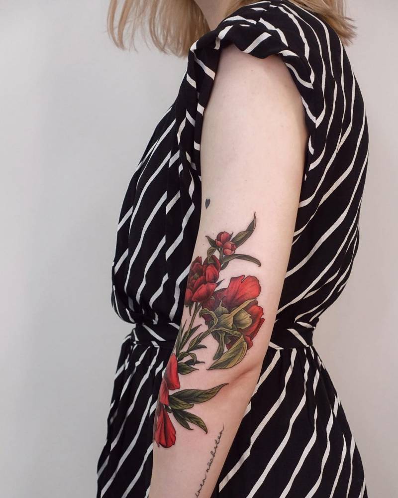 Red peonies tattooed on the arm, illustrative style.