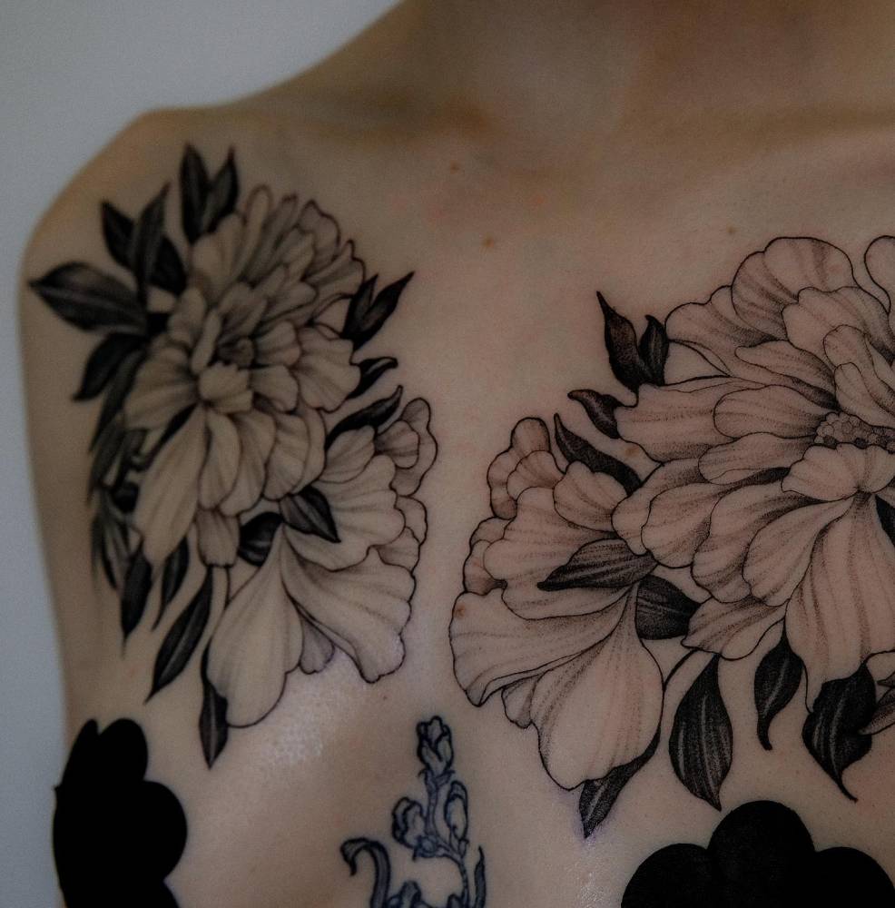 Peonies tattoo located on the chest, illustrative style.
