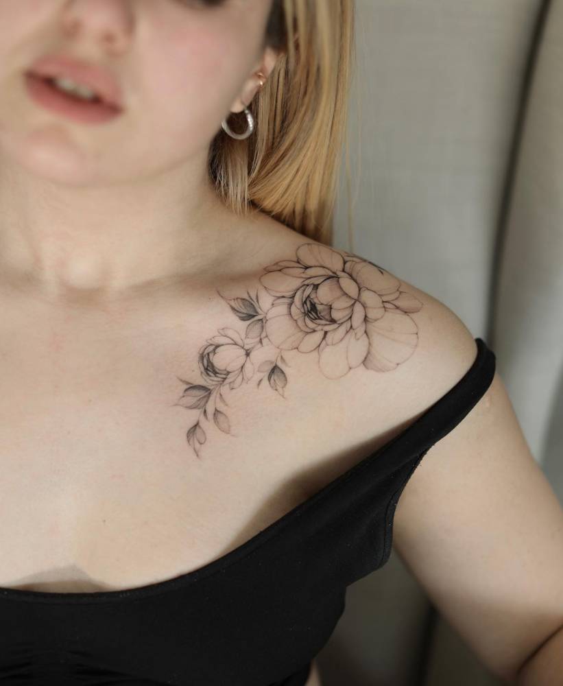 Illustrative style peony tattoo located on the collarbone.