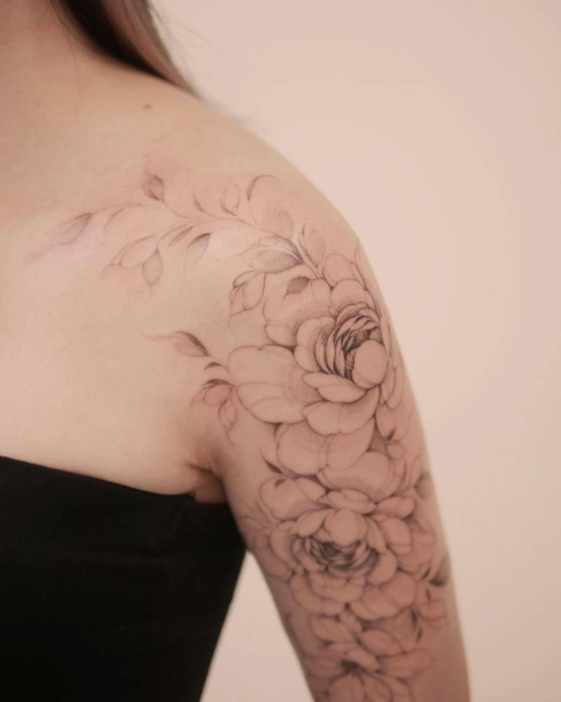 Peonies tattoo located on the upper arm, illustrative style.