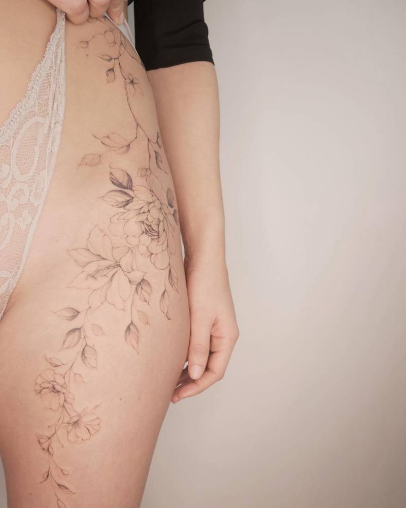 Peony and magnolia tattoo done on the hip, illustrative style.