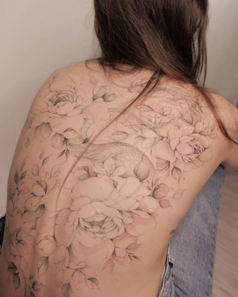 Illustrative style dragon and peonies backpiece tattoo.