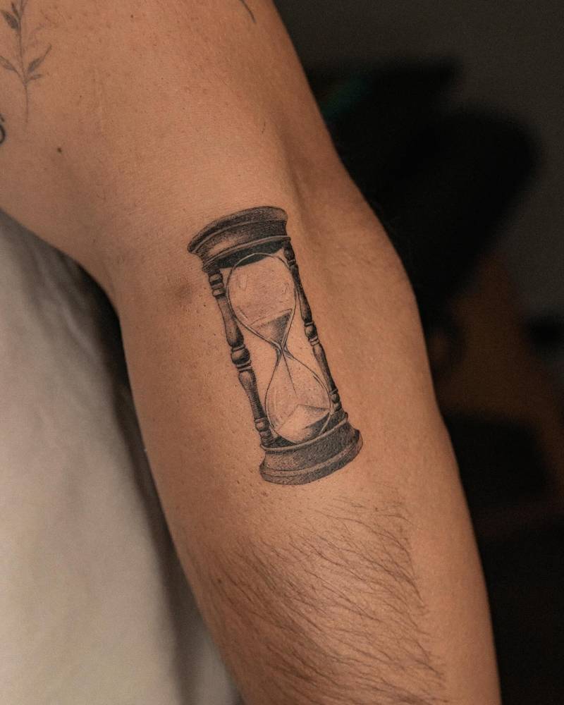 Hourglass tattoo in illustrative style located on the forearm.
